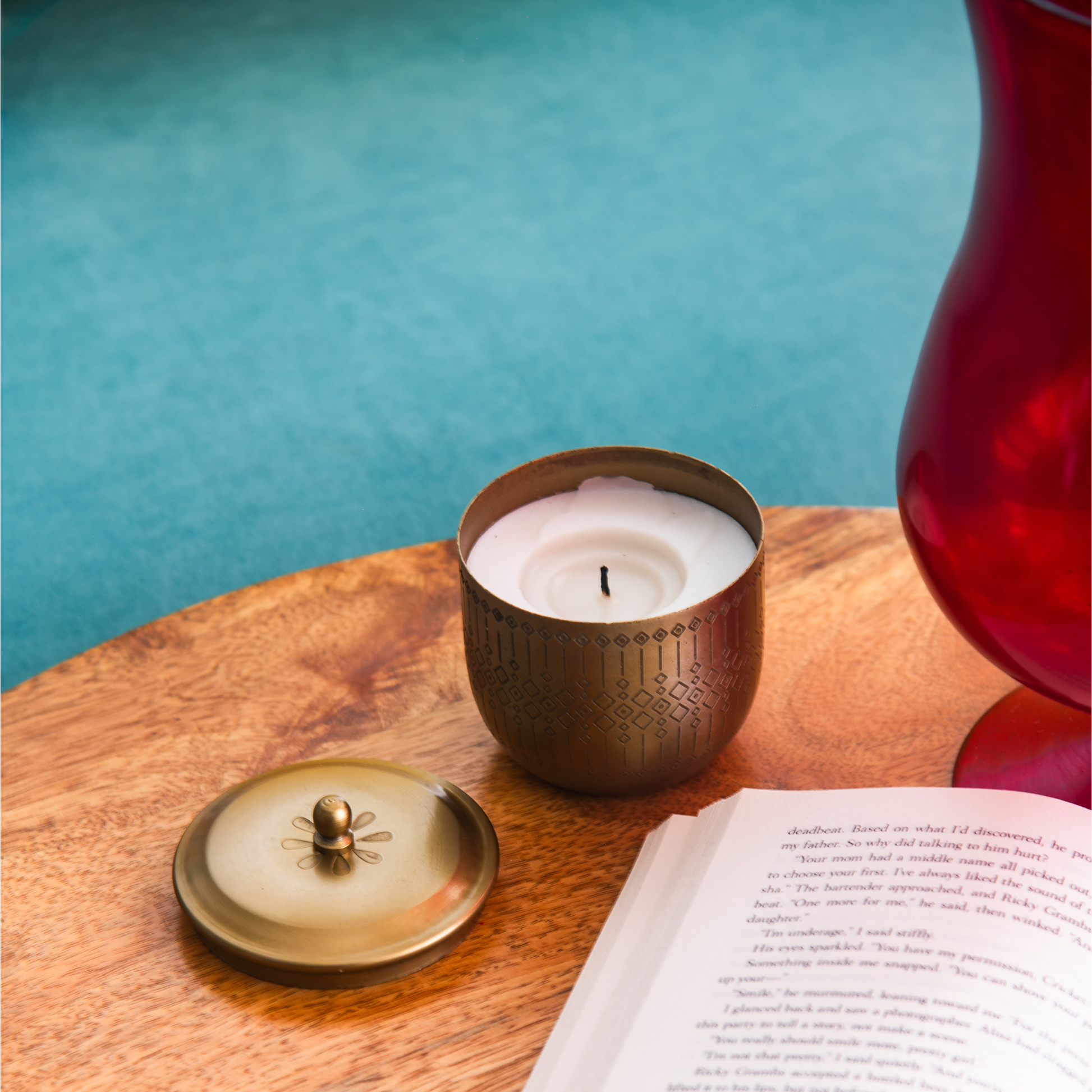 scented candle in metal jar for good vives set on the reading table